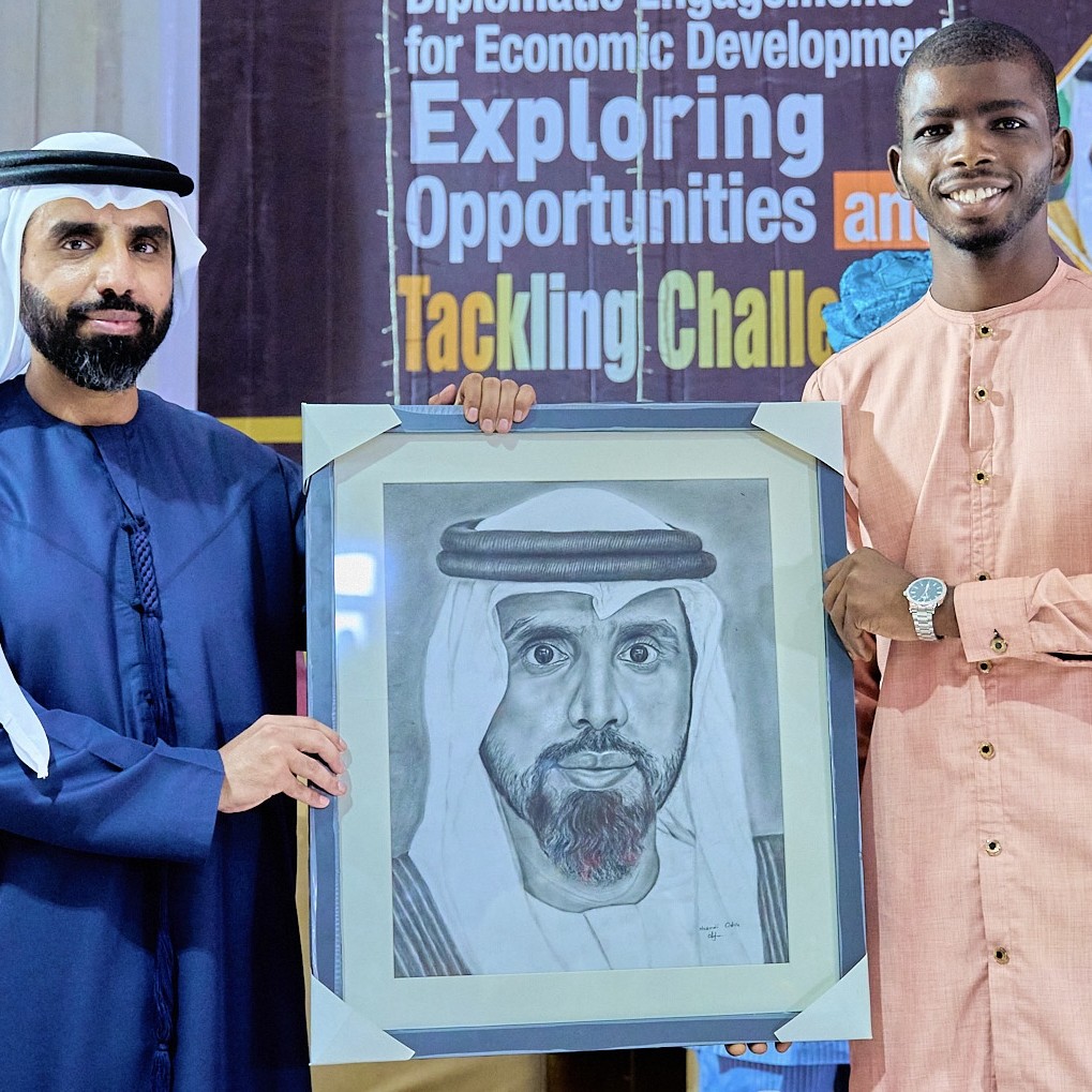 Nnamdi Odife presenting a hand-drawn charcoal portrait to a foreign dignitary
